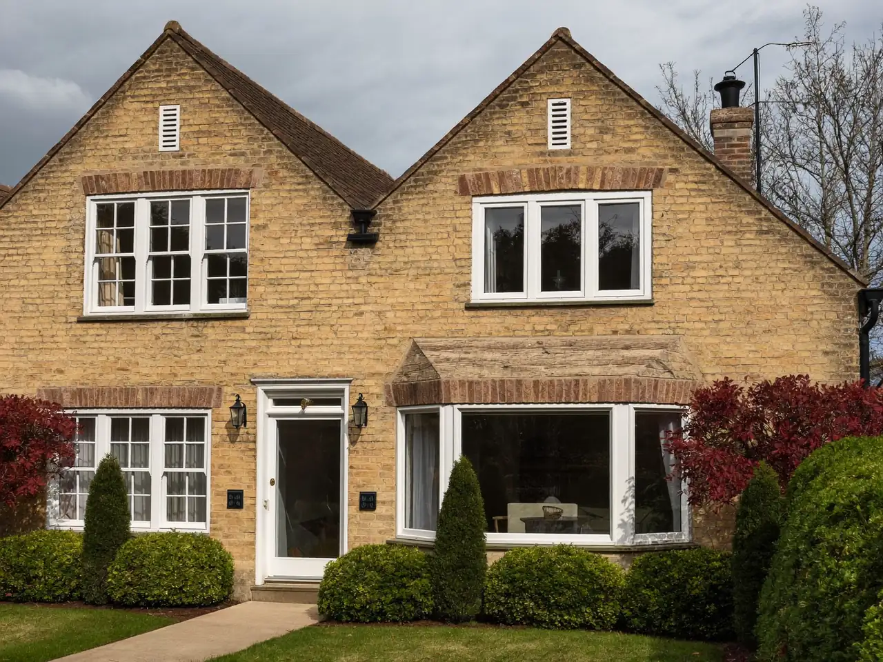 Brick semi-detached home showing a mix of standard and bay window openings